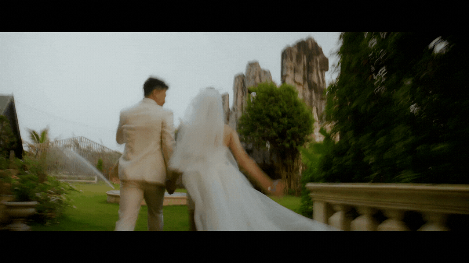 Bride and groom walking hand in hand through a garden